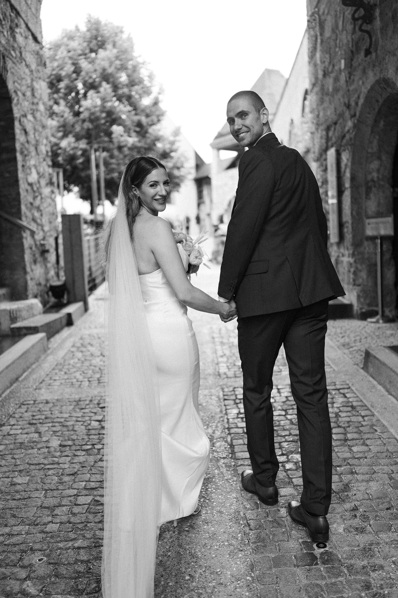 bride and groom walking and looking back over their shoulder
