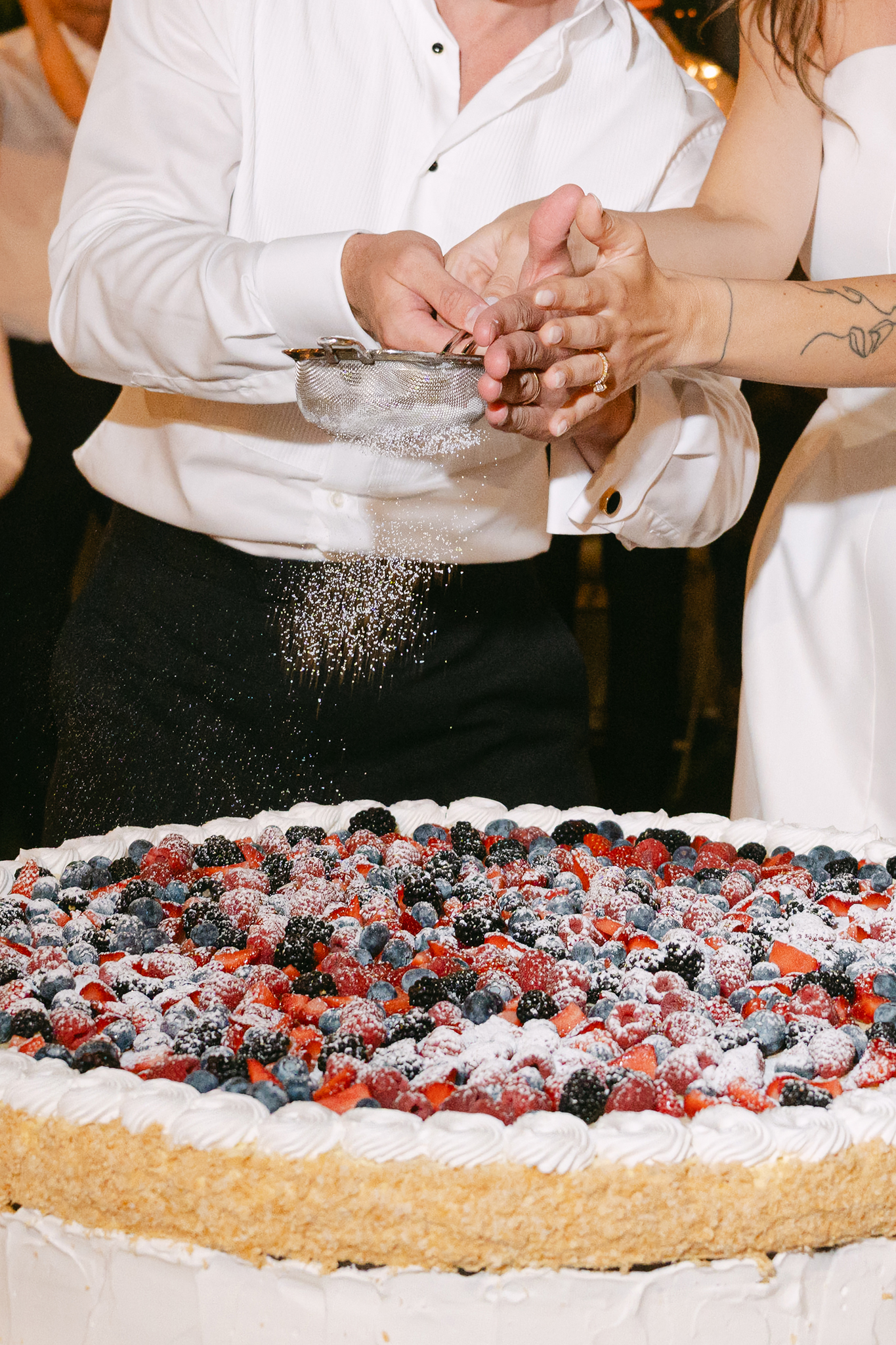 springling sugar over italian wedding cake